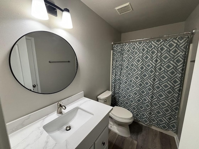 bathroom featuring wood-type flooring, toilet, curtained shower, and vanity