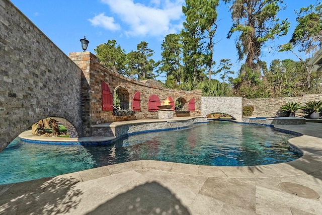 view of swimming pool with an in ground hot tub, pool water feature, and a patio