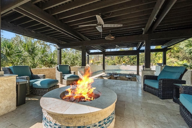 view of patio with ceiling fan and a fire pit