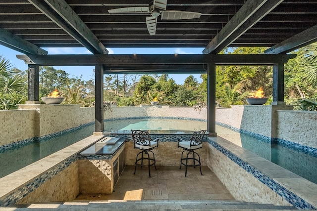 view of patio / terrace with ceiling fan and an outdoor bar