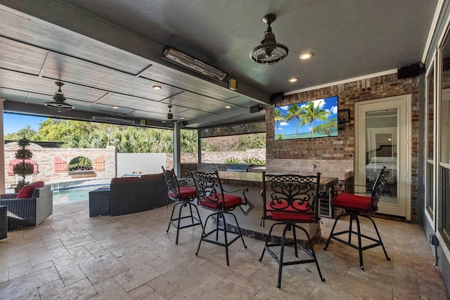 view of patio / terrace with ceiling fan, a fenced in pool, and an outdoor bar