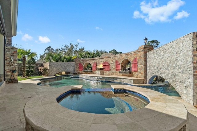 view of pool featuring a patio, pool water feature, and an in ground hot tub