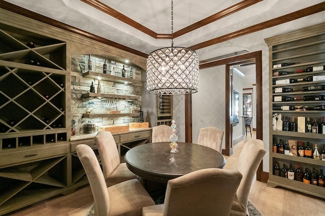 wine cellar with crown molding, indoor bar, and light wood-type flooring