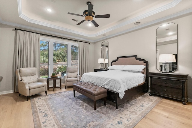 bedroom featuring ornamental molding, ceiling fan, light hardwood / wood-style floors, and a tray ceiling