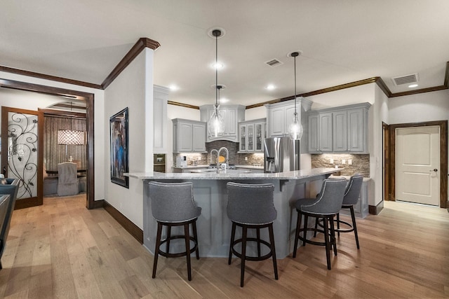 kitchen with gray cabinetry, light hardwood / wood-style floors, and stainless steel fridge with ice dispenser