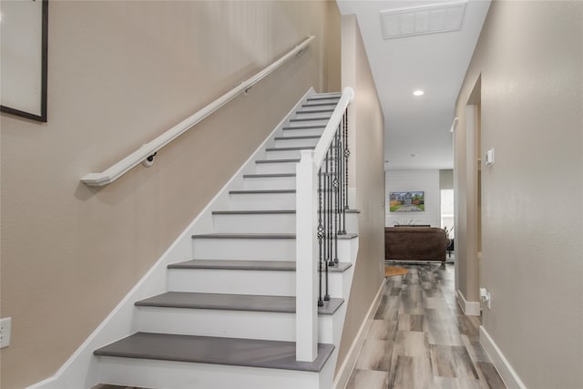 stairs featuring hardwood / wood-style floors