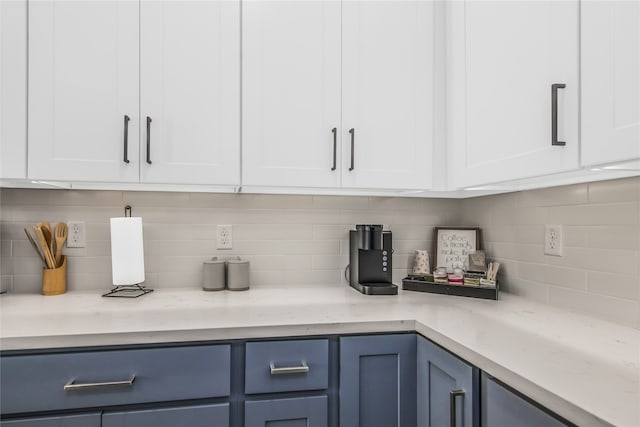 bar featuring tasteful backsplash, blue cabinets, and white cabinets