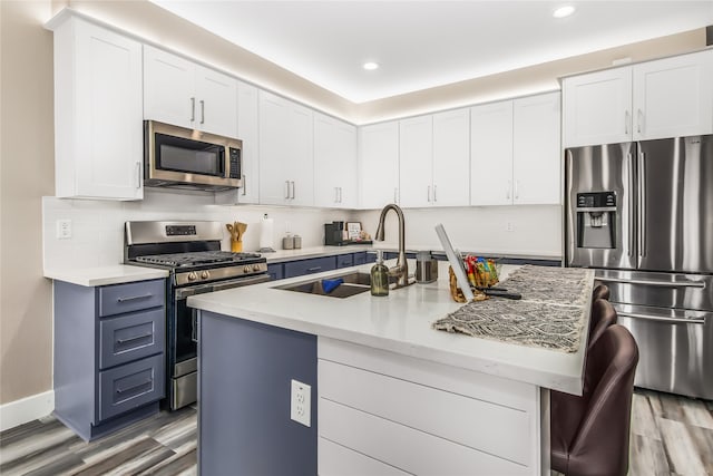 kitchen featuring white cabinetry, appliances with stainless steel finishes, sink, and a kitchen island with sink