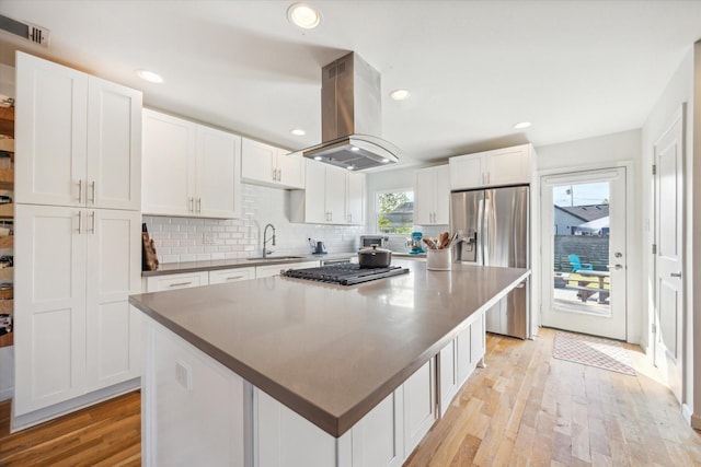 kitchen with white cabinetry, island range hood, a center island, and stainless steel fridge with ice dispenser