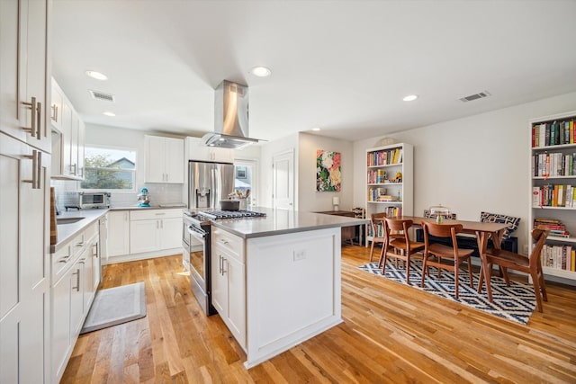 kitchen with white cabinetry, stainless steel appliances, a center island, and island exhaust hood