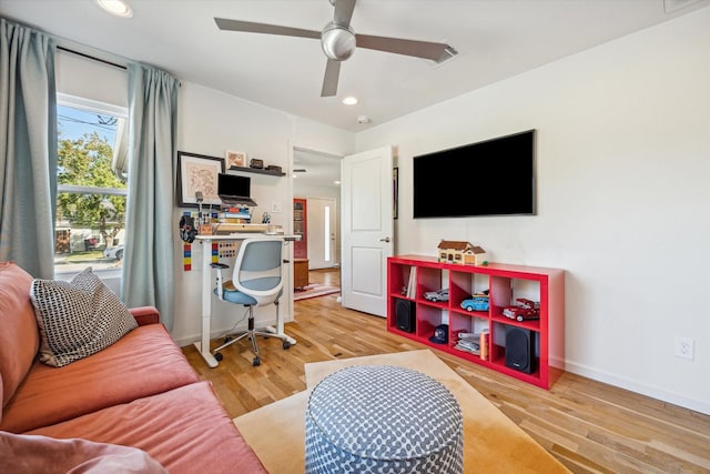 home office with ceiling fan and light hardwood / wood-style floors