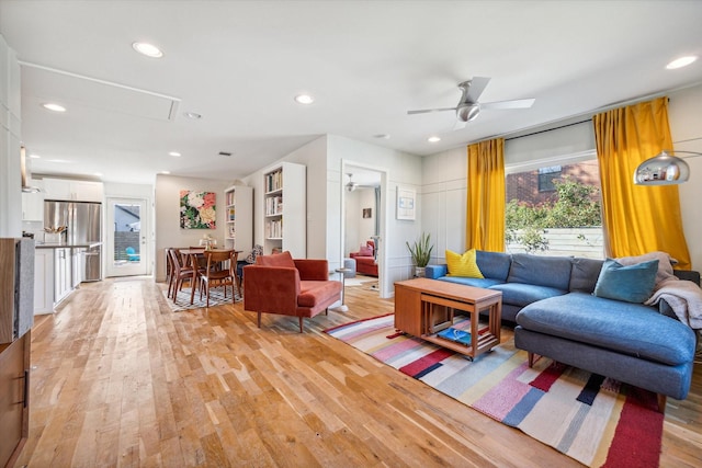 living room with ceiling fan and light hardwood / wood-style flooring