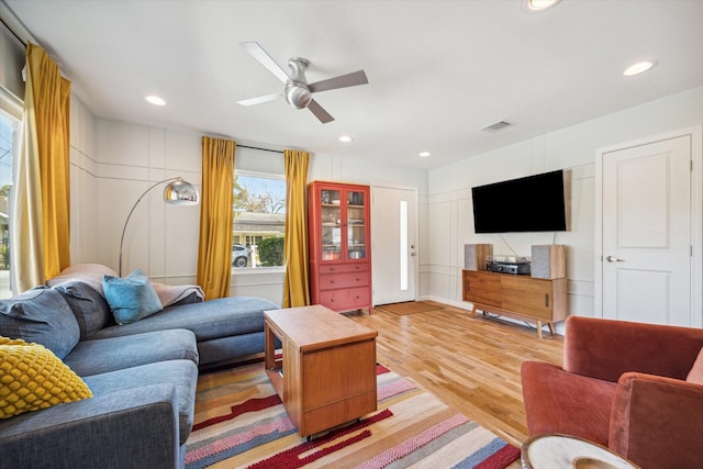 living room featuring wood-type flooring and ceiling fan