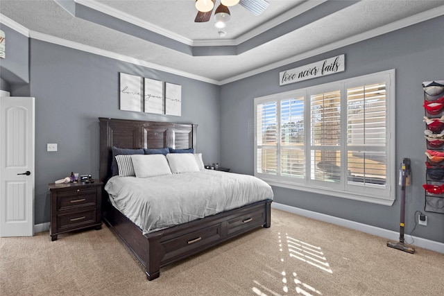 bedroom with crown molding, light colored carpet, a raised ceiling, and ceiling fan