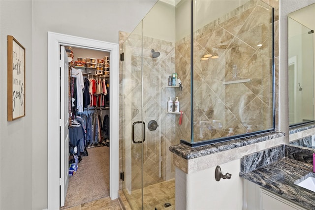 bathroom featuring walk in shower and vanity