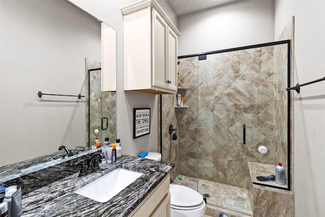 bathroom with walk in shower, vanity, and toilet