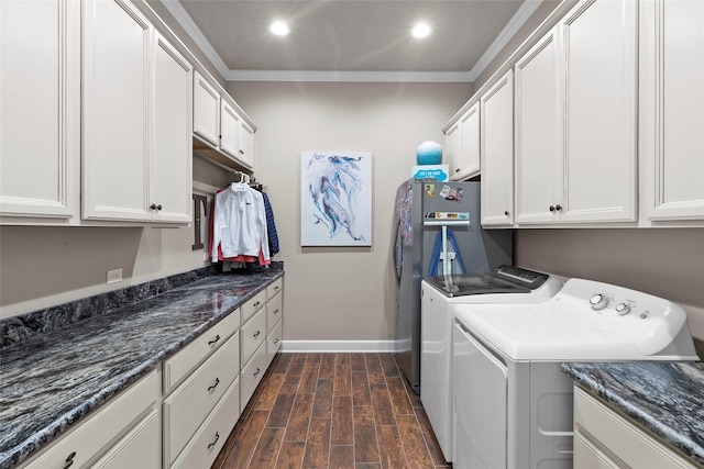 laundry room featuring cabinets, ornamental molding, and washing machine and clothes dryer