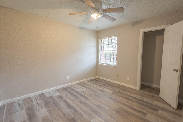 unfurnished bedroom featuring ceiling fan, light hardwood / wood-style floors, a closet, and a textured ceiling