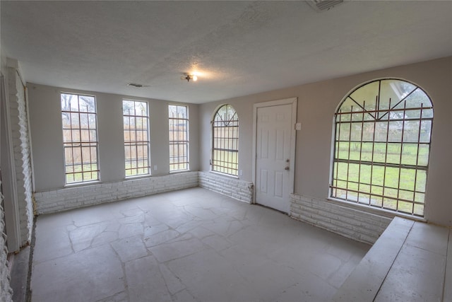 interior space featuring a wealth of natural light and a textured ceiling