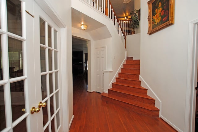 stairs with wood-type flooring and french doors