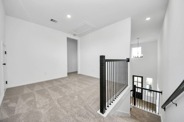 interior space featuring light colored carpet and a notable chandelier