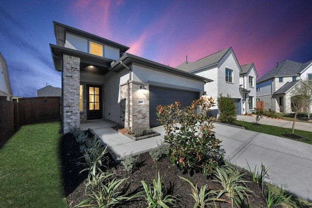 view of front of property featuring a garage and a lawn