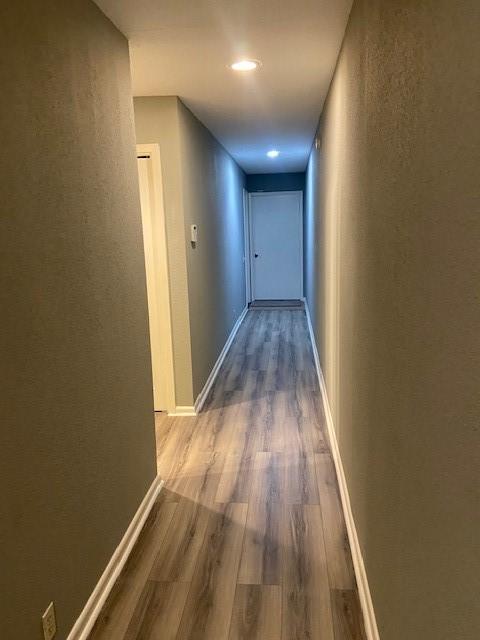 corridor with hardwood / wood-style flooring