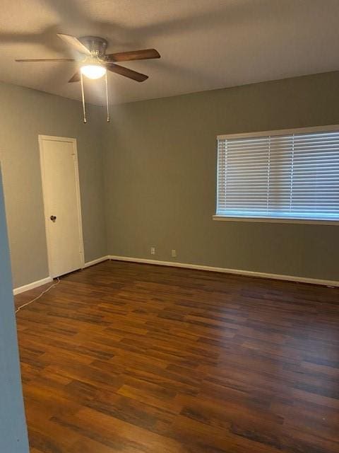 spare room with dark wood-type flooring and ceiling fan