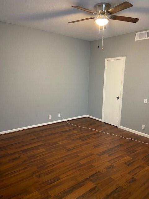 spare room with dark hardwood / wood-style floors and ceiling fan