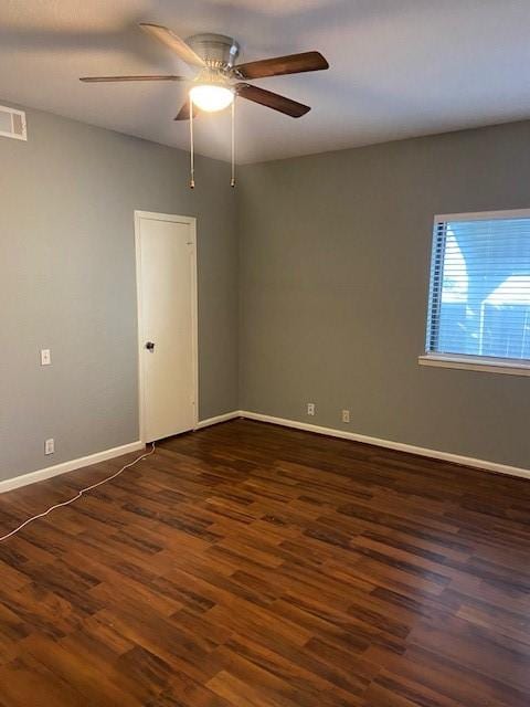 empty room featuring dark wood-type flooring and ceiling fan