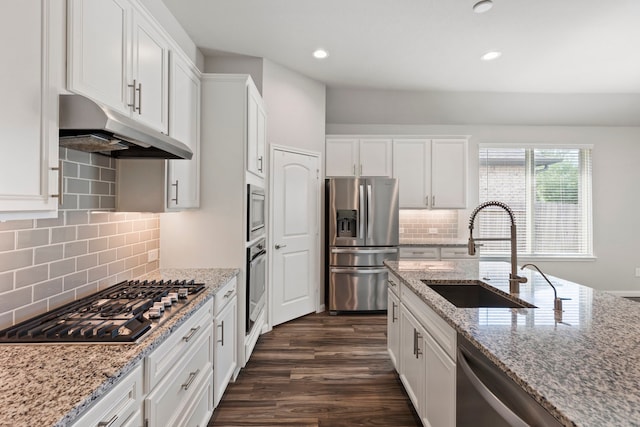 kitchen featuring light stone counters, sink, stainless steel appliances, and white cabinets