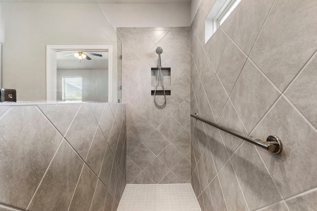 bathroom with ceiling fan and tiled shower