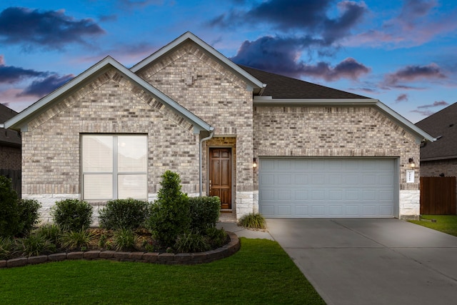 view of front of home featuring a garage and a lawn