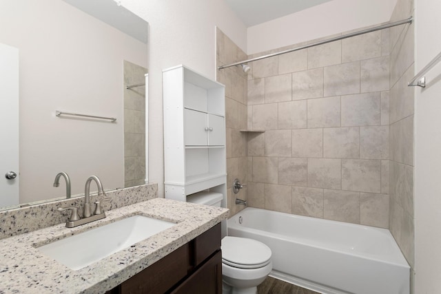 full bathroom featuring vanity, tiled shower / bath combo, toilet, and hardwood / wood-style flooring