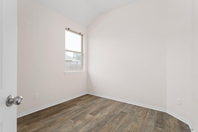 unfurnished room featuring vaulted ceiling and dark hardwood / wood-style flooring