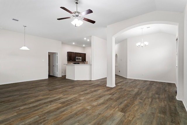 unfurnished living room with lofted ceiling, dark wood-type flooring, and ceiling fan with notable chandelier