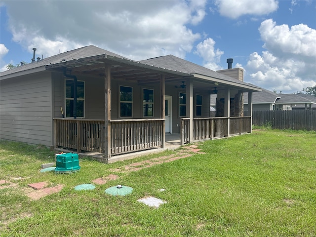 rear view of house featuring a yard and ceiling fan