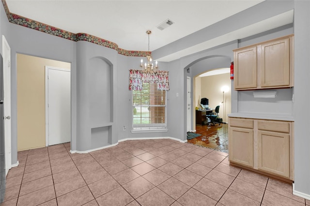 unfurnished dining area featuring a notable chandelier and light tile patterned floors