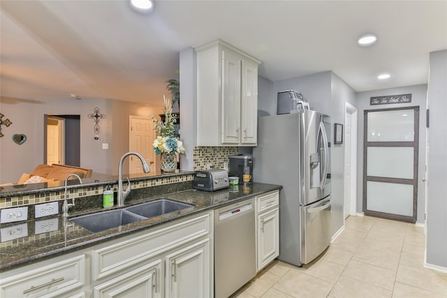 kitchen featuring light tile patterned flooring, sink, white cabinets, backsplash, and stainless steel appliances