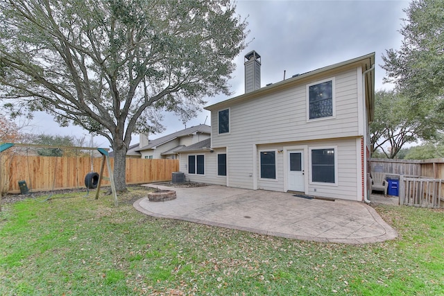 rear view of property with a yard, a fire pit, a patio area, and central air condition unit