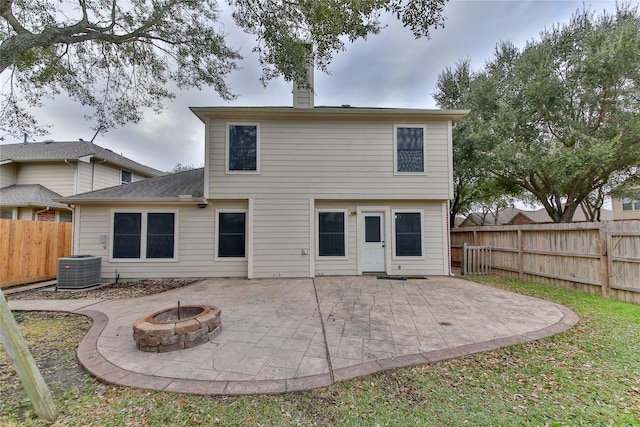 rear view of house featuring a patio area, central air condition unit, and an outdoor fire pit