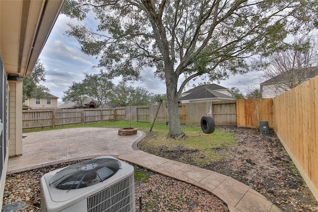 view of yard with cooling unit, a patio, and a fire pit