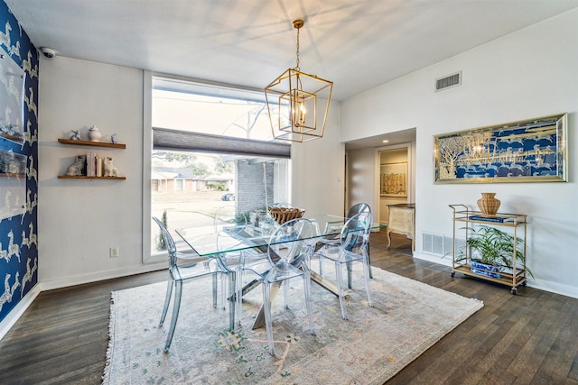 dining space featuring dark wood-type flooring and an inviting chandelier