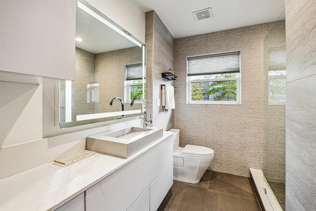 bathroom with tile patterned floors, vanity, toilet, and tile walls