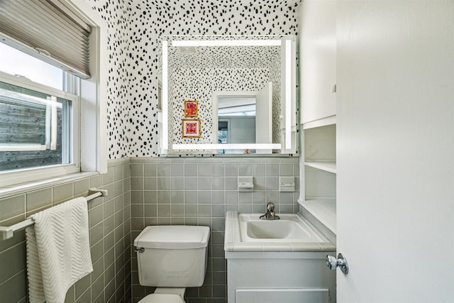 bathroom with vanity, tile walls, and toilet