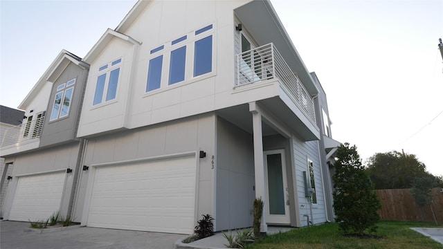 view of side of property featuring a garage and a balcony