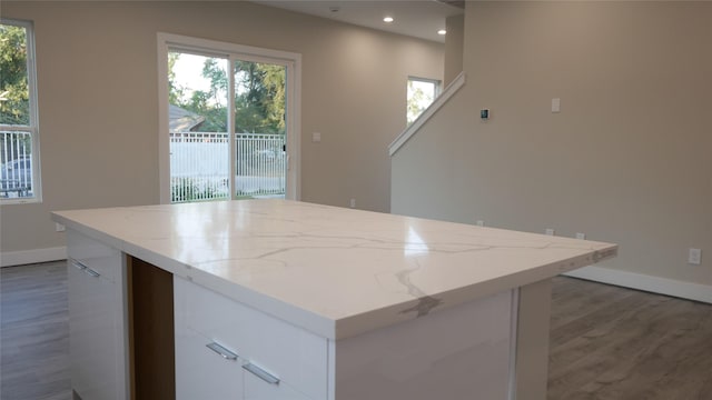 kitchen with a center island, a wealth of natural light, white cabinets, and dark wood-type flooring