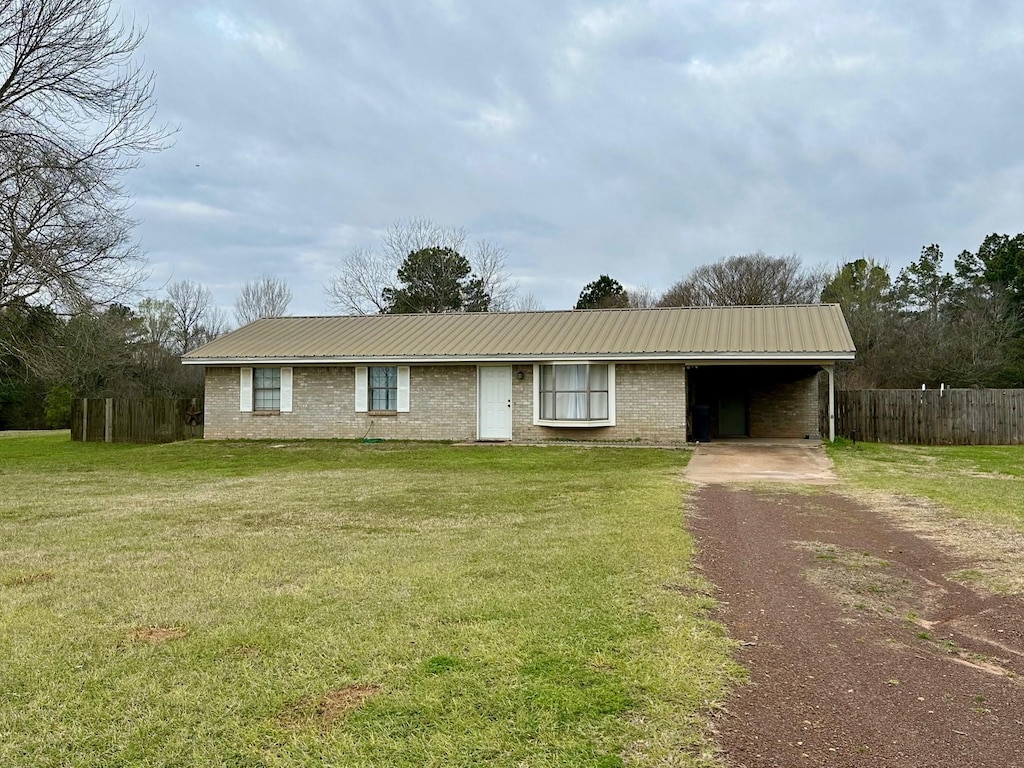 ranch-style house featuring a front lawn and a carport