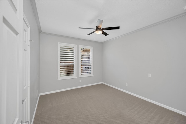 spare room with carpet flooring, crown molding, baseboards, and ceiling fan