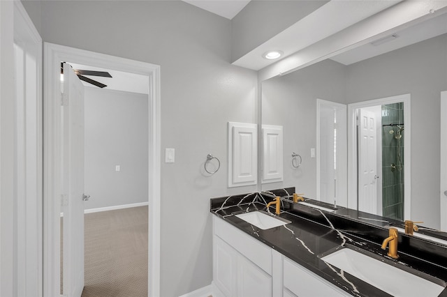 bathroom featuring a ceiling fan, a sink, baseboards, and double vanity